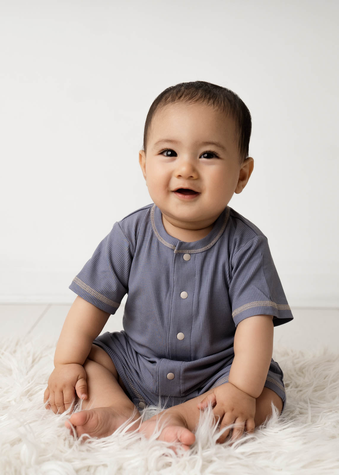 Baby wearing a Mini Ribbed Romper in Royal Blue on a white background