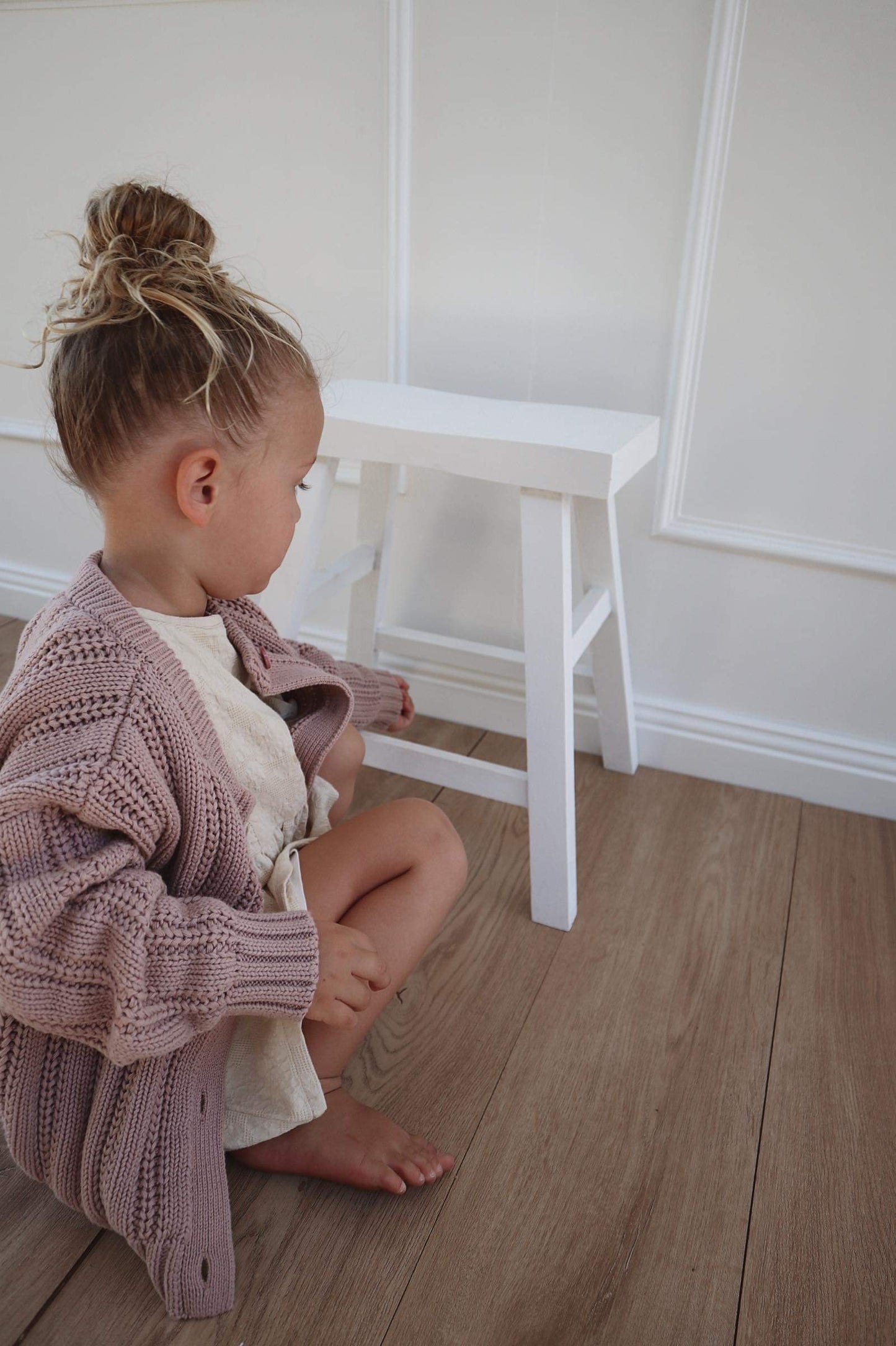 A young child wearing a Chunky Knitted Cardigan in Rose Pink