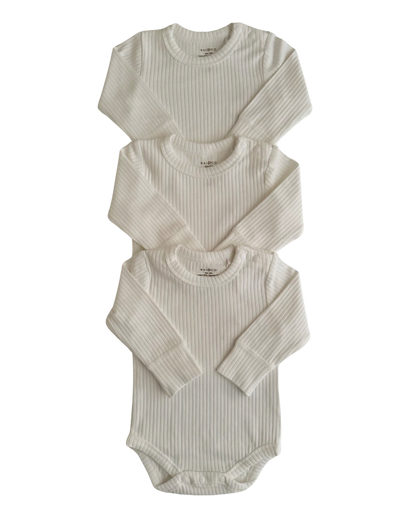 Three Basics Long Sleeve Bodysuits for babies, stacked on top of each other against a checkerboard transparency pattern. background.