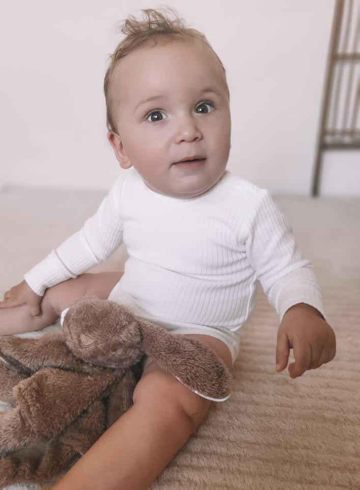 a baby wearing a Basics Long Sleeve Bodysuit in White 