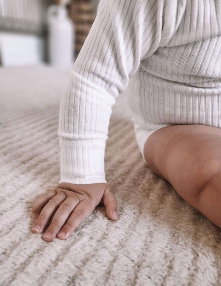 A close-up of the Basics Long Sleeve Bodysuit in White.