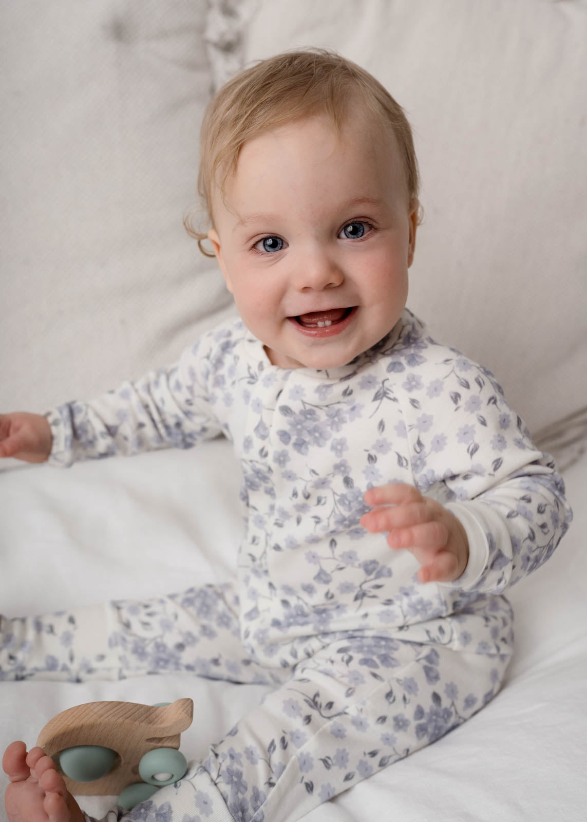 Baby wearing a Bloom Floral Onesie Blue sitting on a white surface