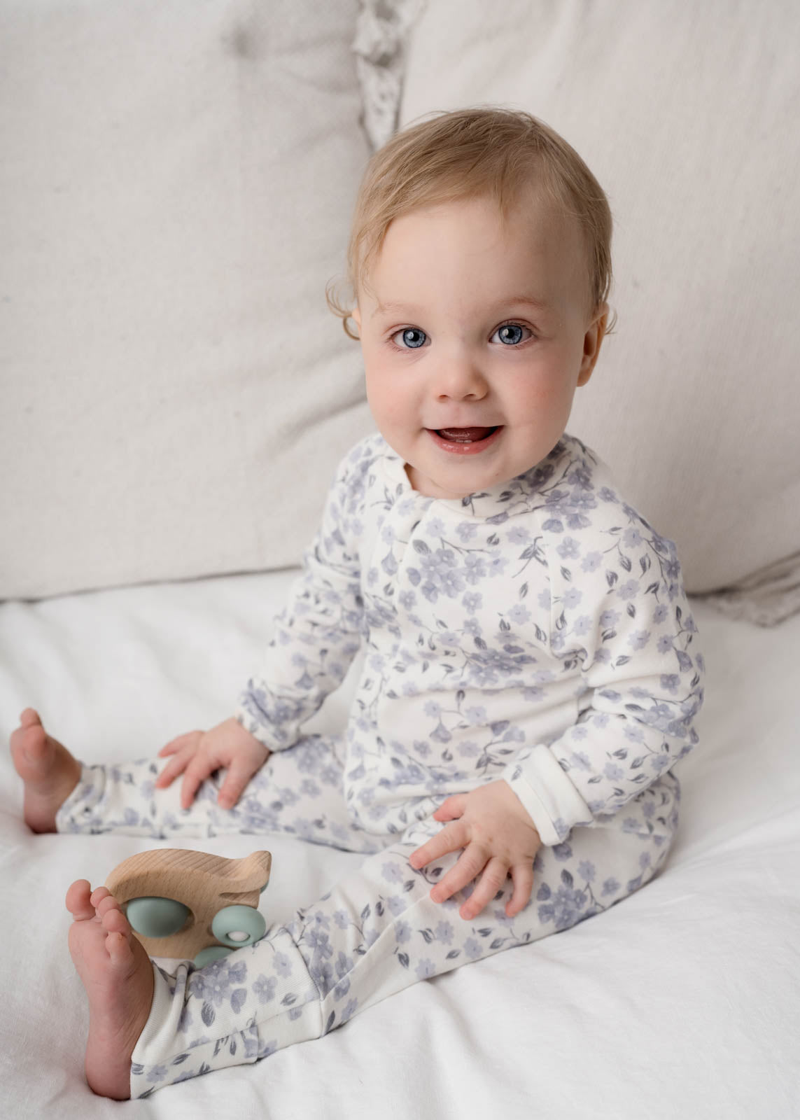 Baby in a Bloom Floral Onesie Blue sitting on a white surface