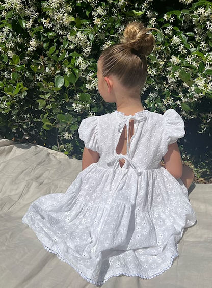 a young girl wearing a Eliza Embroidered Lace Dress in White 