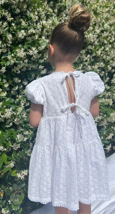 a young child wearing a Eliza Embroidered Lace Dress in White 