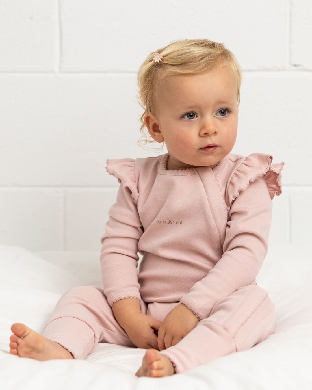 babu wearing a Frilled Apple Onesie in Baby Pink