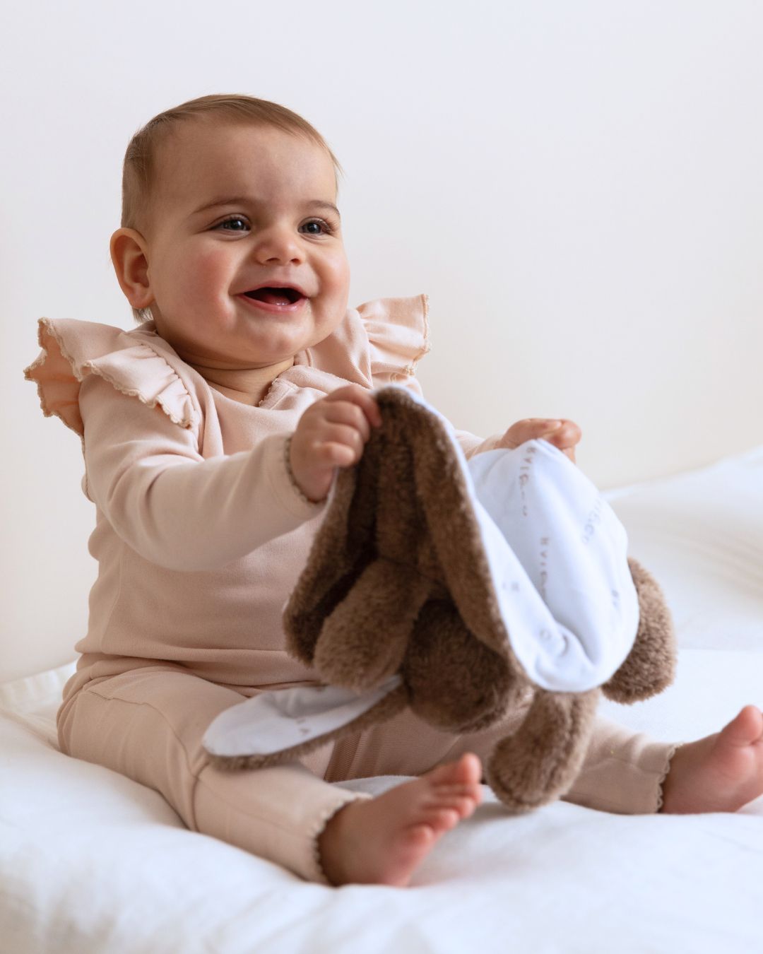 baby wearing Frilled Apple Onesie in Baby Pink on a white background