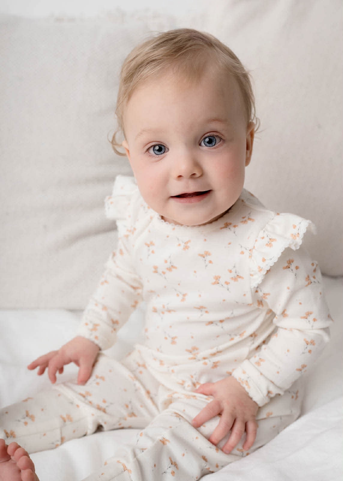 Baby wearing Rai & Co Frilled Ollie Floral Onesie Beige