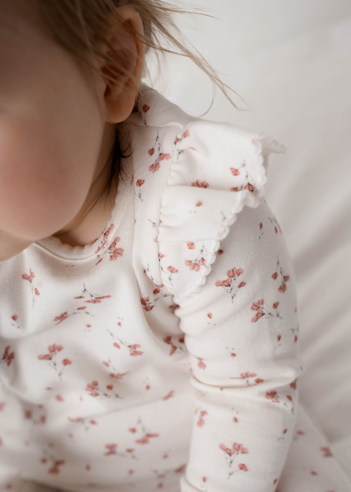 Baby wearing Rai & Co Frilled Ollie Floral Onesie Pink