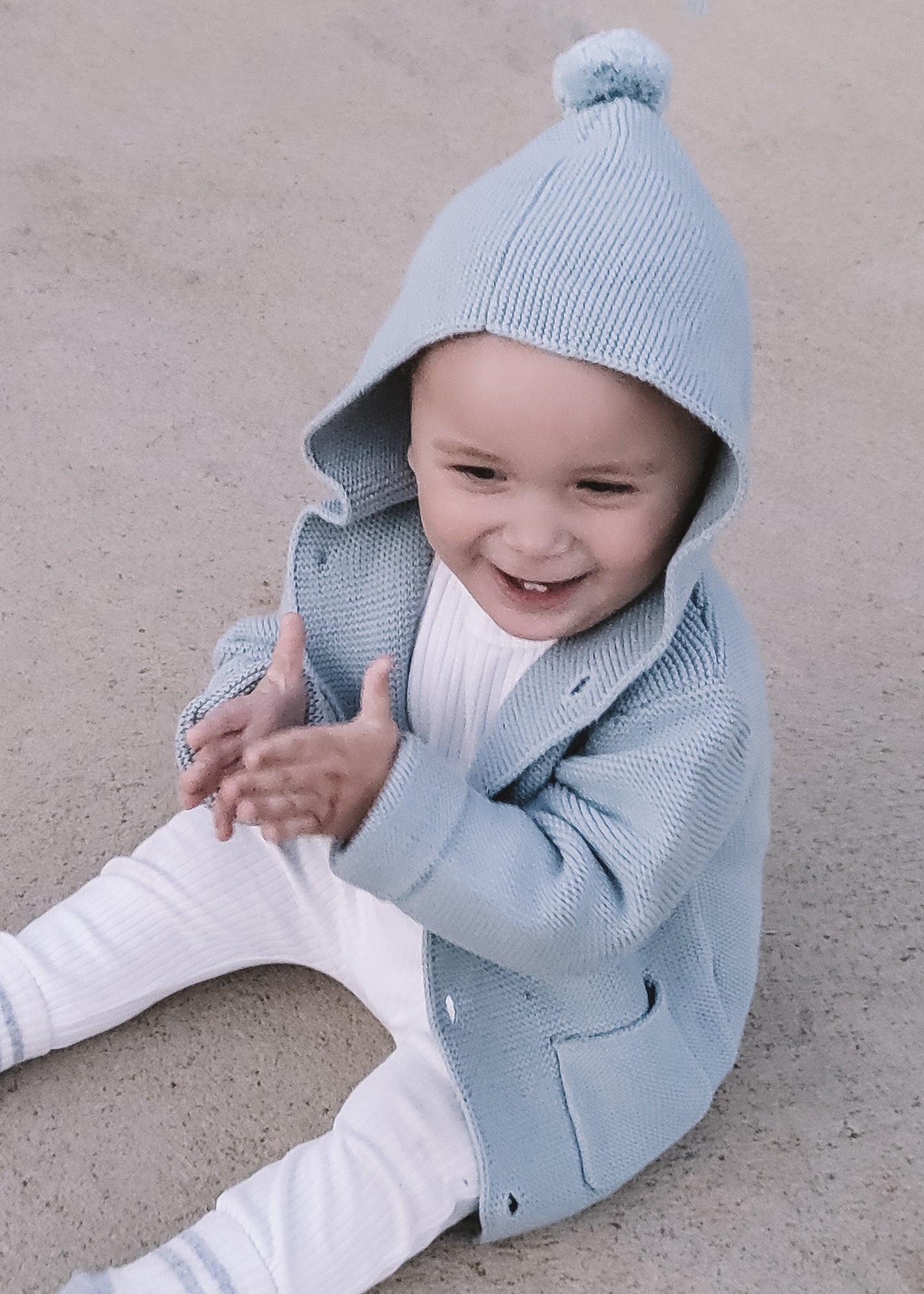a baby wearing a Hooded Knit in Blue 