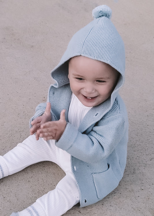 a baby wearing a Hooded Knit in Blue 