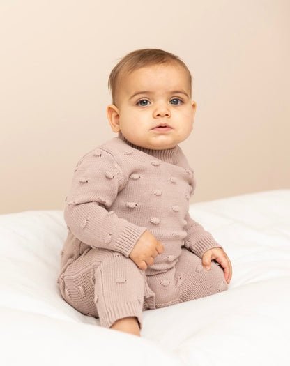baby wearing a Knitted Romper in Dusty Pink 