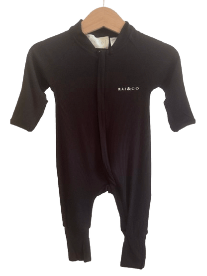 Lightweight Eco Onesie in Black with a brand logo on a hanger against a checkerboard transparency pattern 