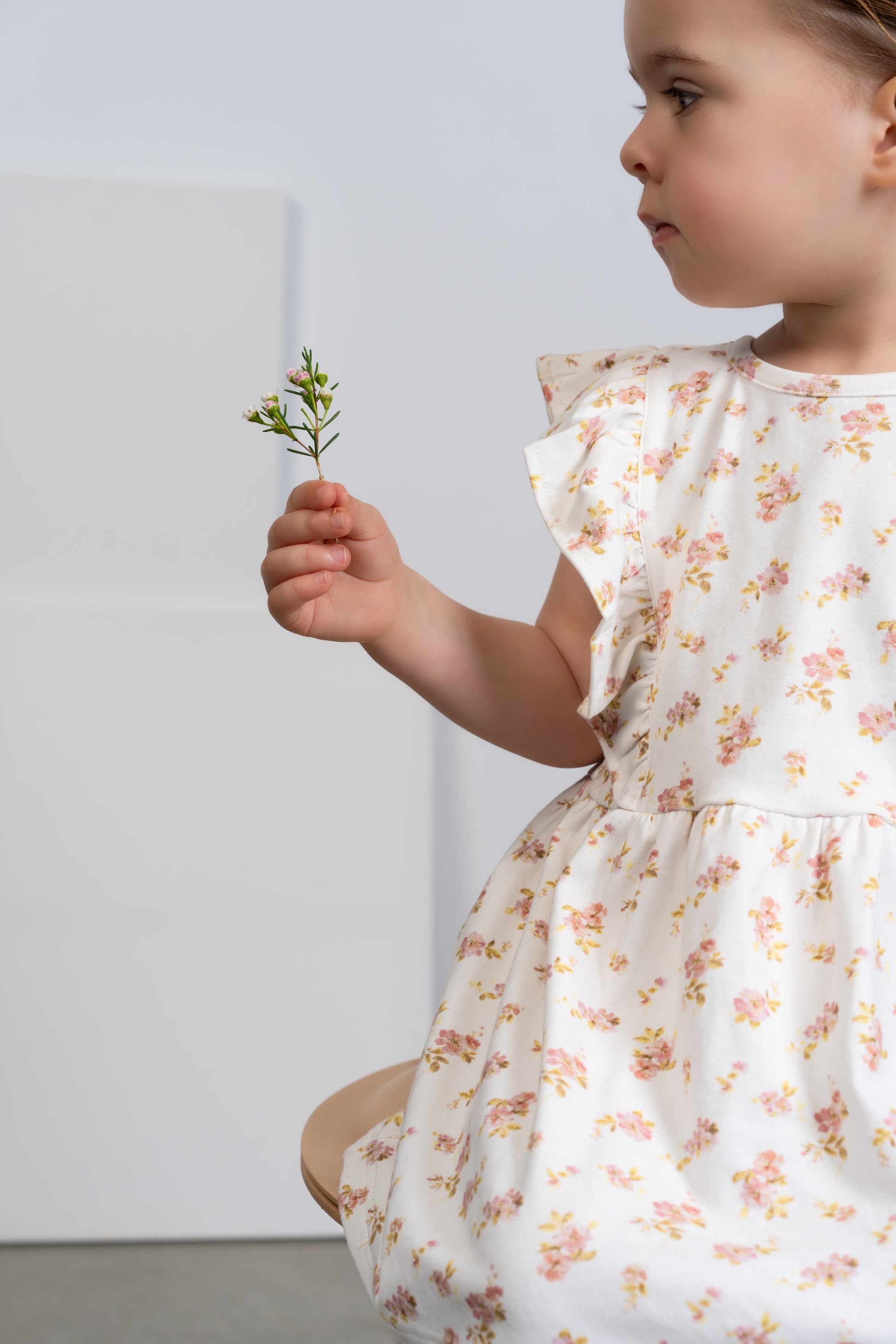 a young child wearing a Lottie Floral Dress With Pilchers in Pink Floral on a white background. 