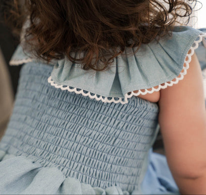 Close-up of a child wearing a Maddie Dress in Denim