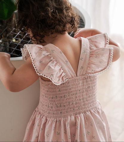 Child wearing a Maddie Dress in Pink Floral standing indoors.