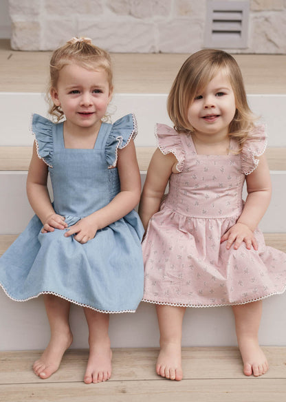 Two young girls in Maddie Dress in Pink Floral and Denim sitting on a staircase.