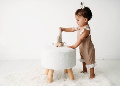 Baby wearing a Mini Ribbed Lace Frill Romper in Beige on a white background