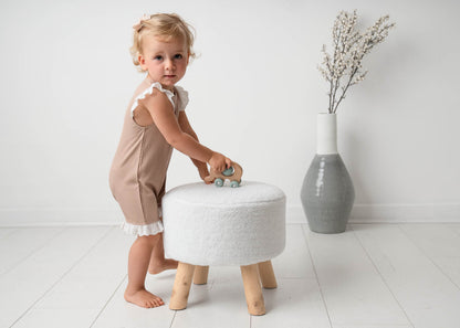 Baby wearing a Mini Ribbed Lace Frill Romper in Beige standing on a white background