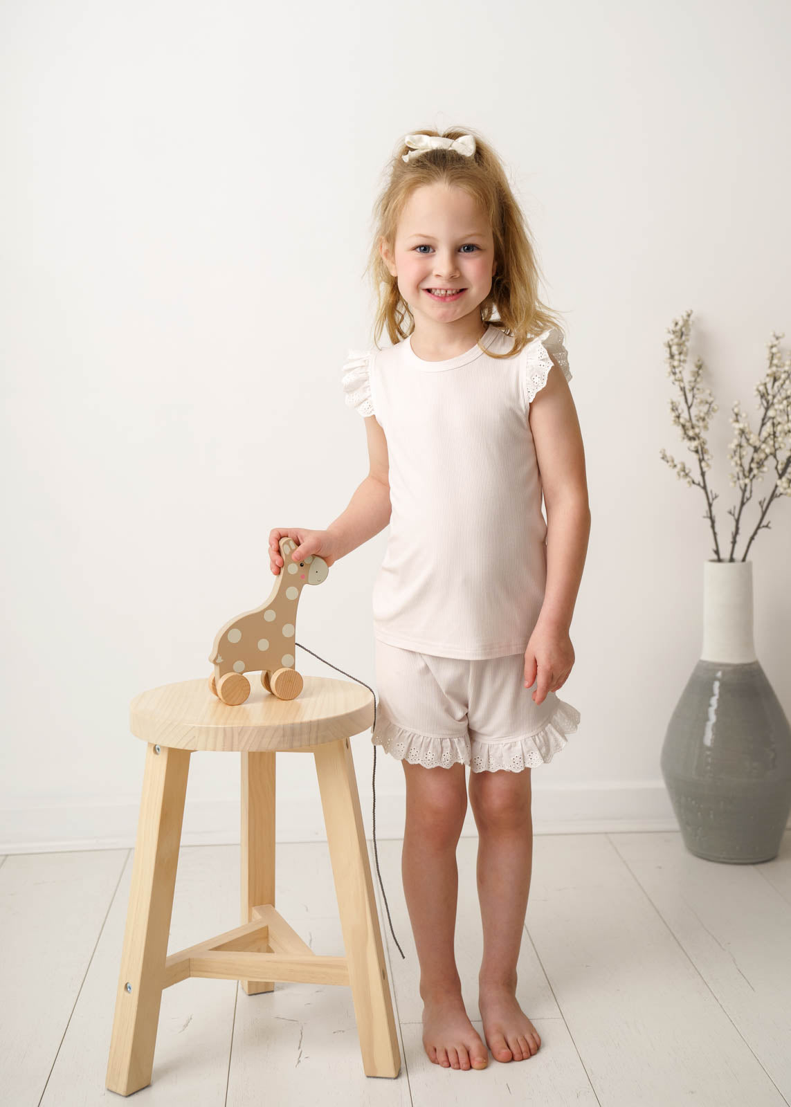 A young girl wearing a Mini Ribbed Lace Frill in White 