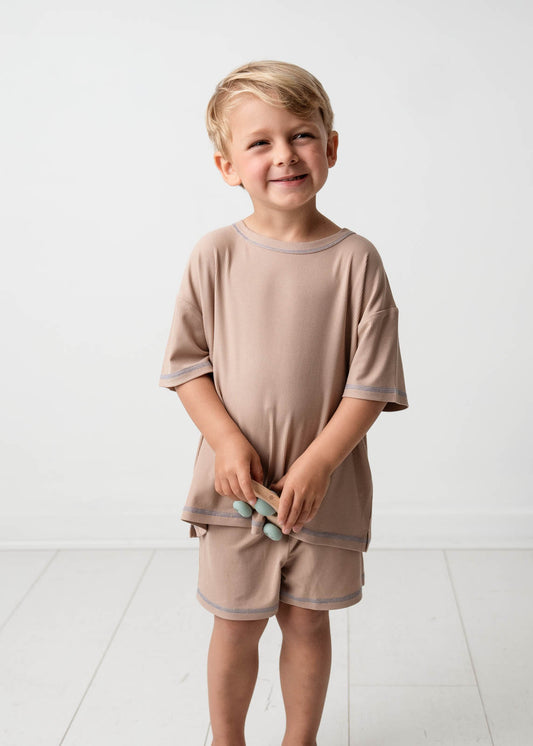 Young boy wearing a Mini Ribbed Oversized T-shirt in Beige on a white background 