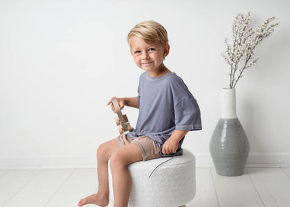 A boy wearing a Mini Ribbed Oversized T-shirt in Royal Blue on a white background