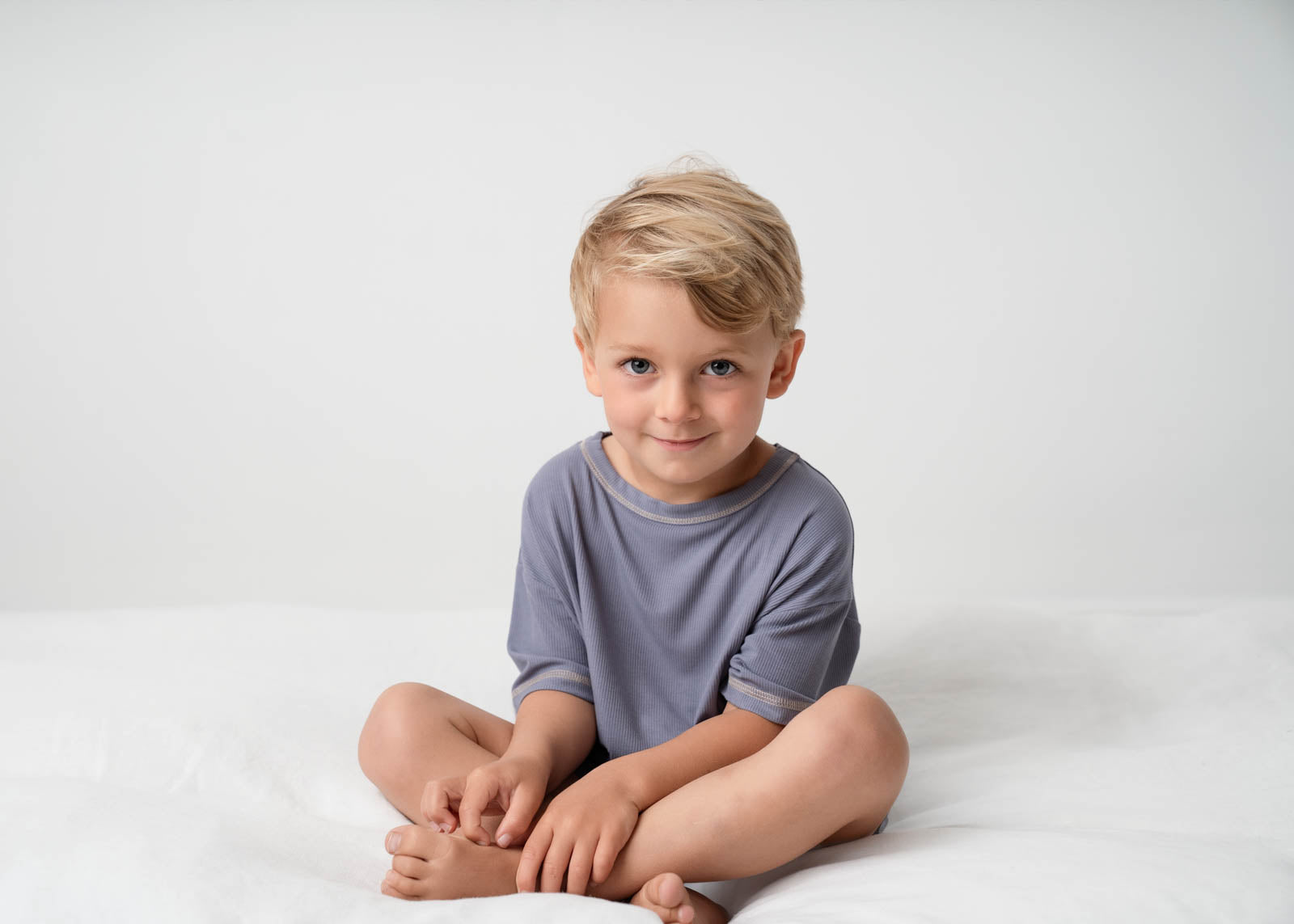 A boy wearing a Mini Ribbed Oversized T-shirt in Royal Blue on a white background