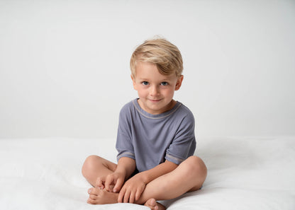 A boy wearing a Mini Ribbed Oversized T-shirt in Royal Blue on a white background