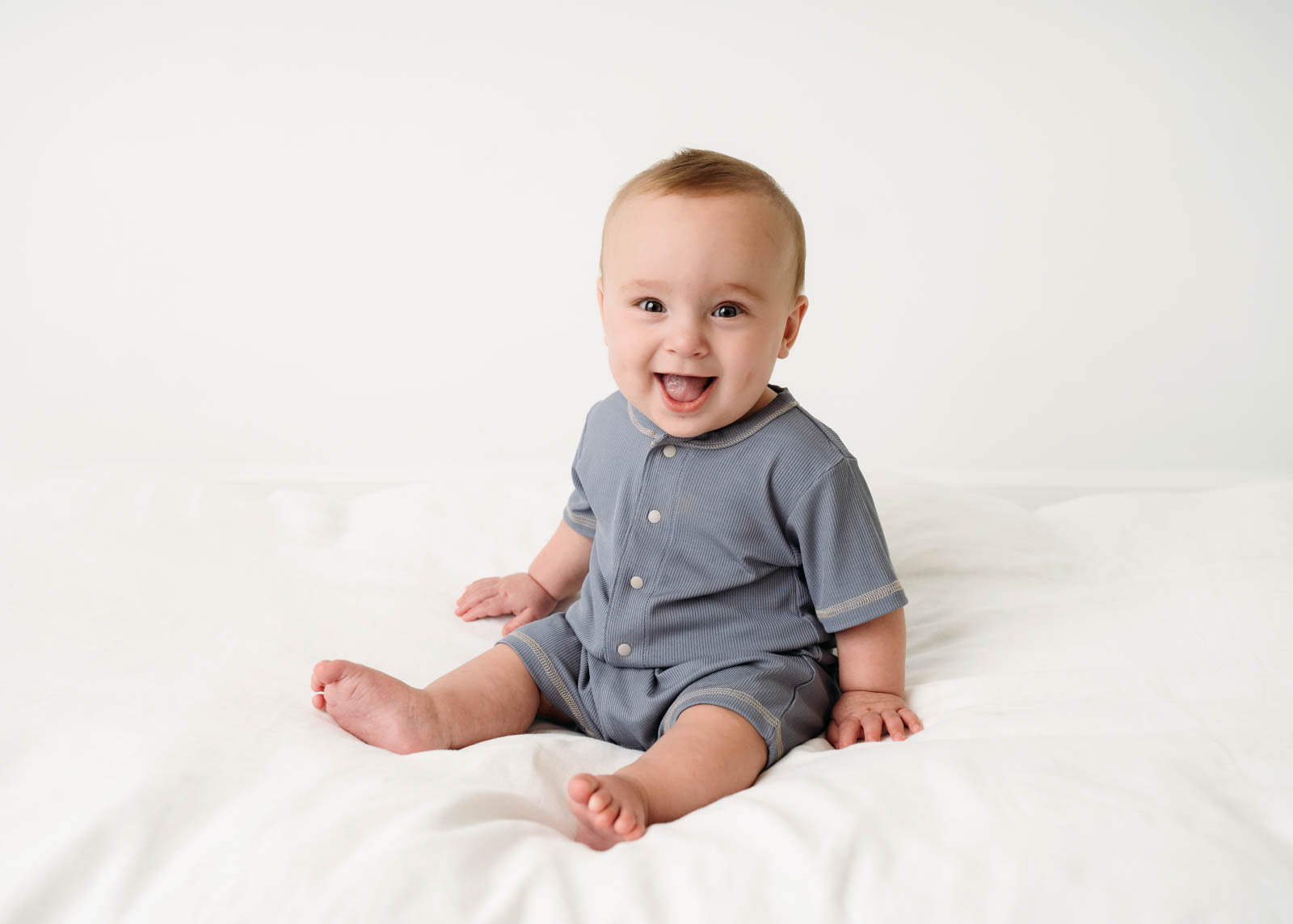 Baby wearing a Mini Ribbed Romper in Royal Blue on a white background