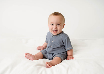Baby wearing a Mini Ribbed Romper in Royal Blue on a white background