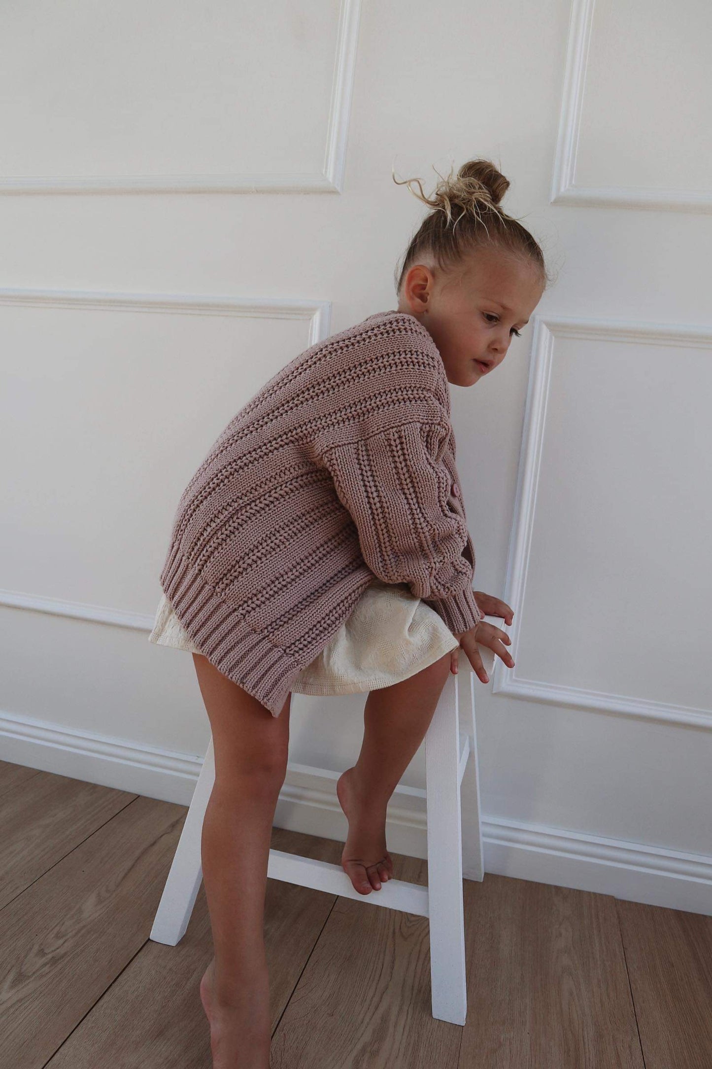 a  young child wearing a Chunky Knitted Cardigan in Rose Pink
