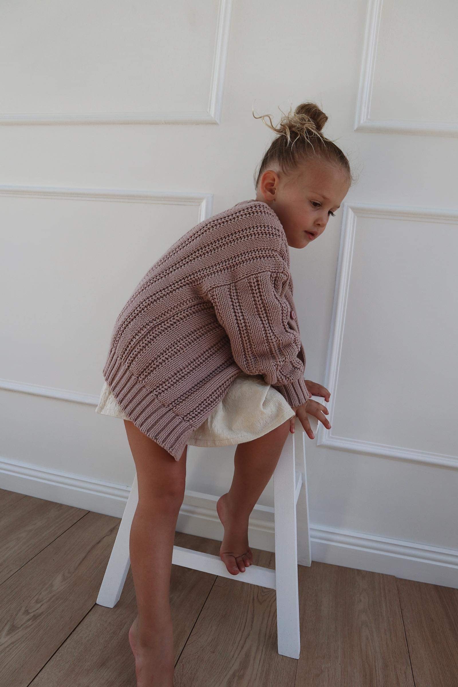 a  young child wearing a Chunky Knitted Cardigan in Rose Pink