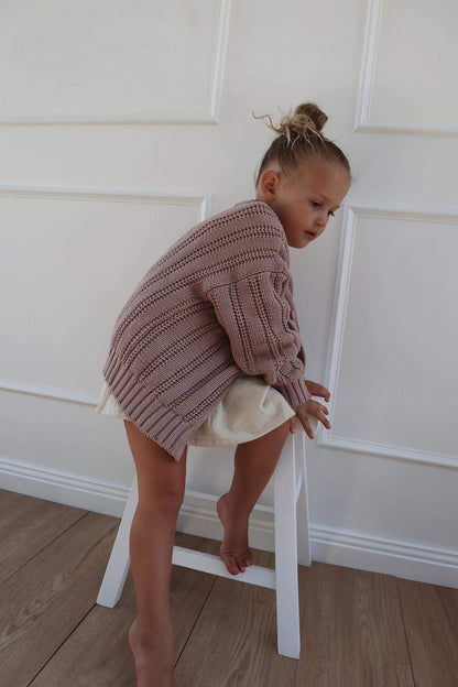 a  young child wearing a Chunky Knitted Cardigan in Rose Pink