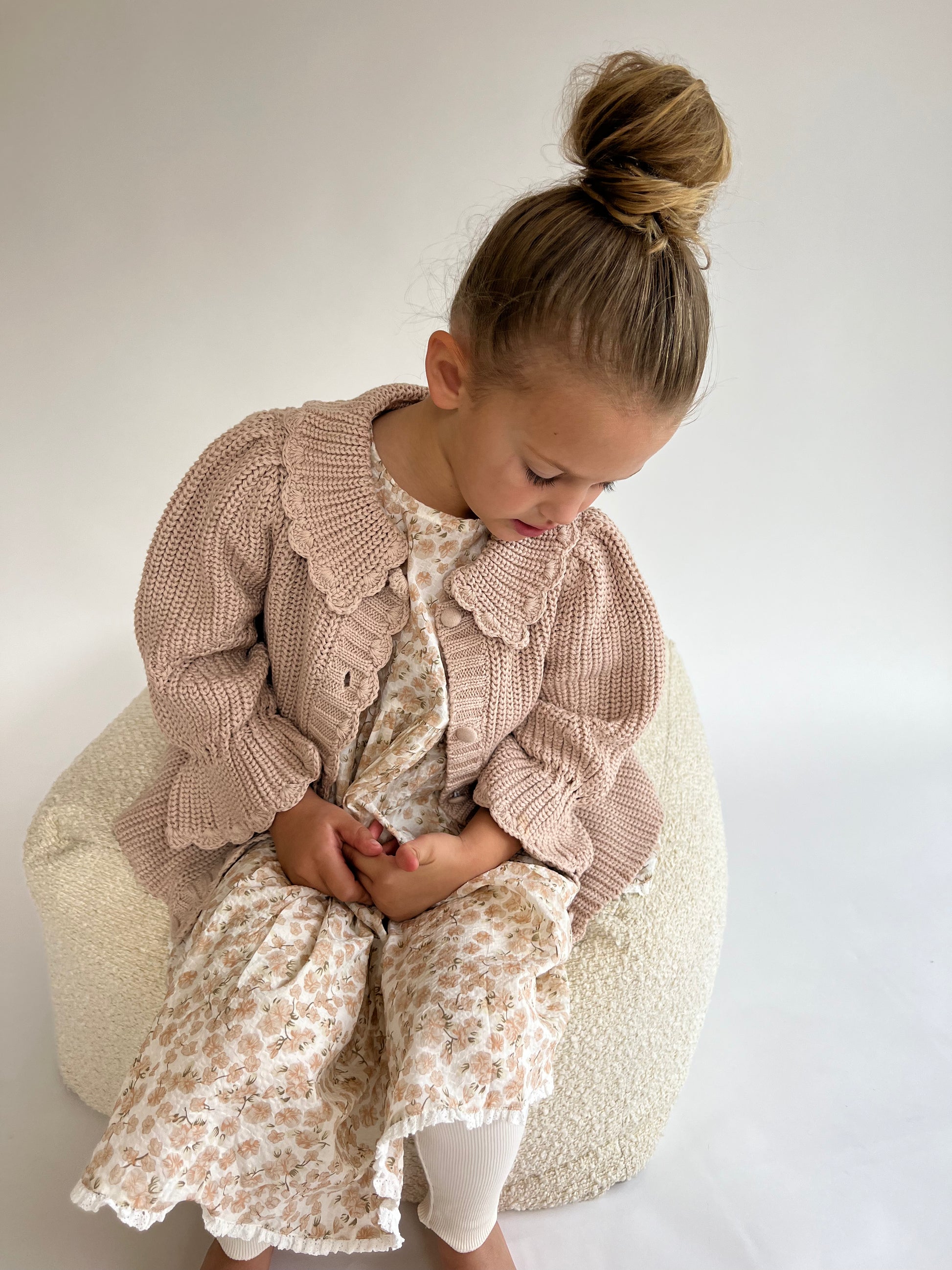 a young child wearing a Kenya Cardigan on a white background