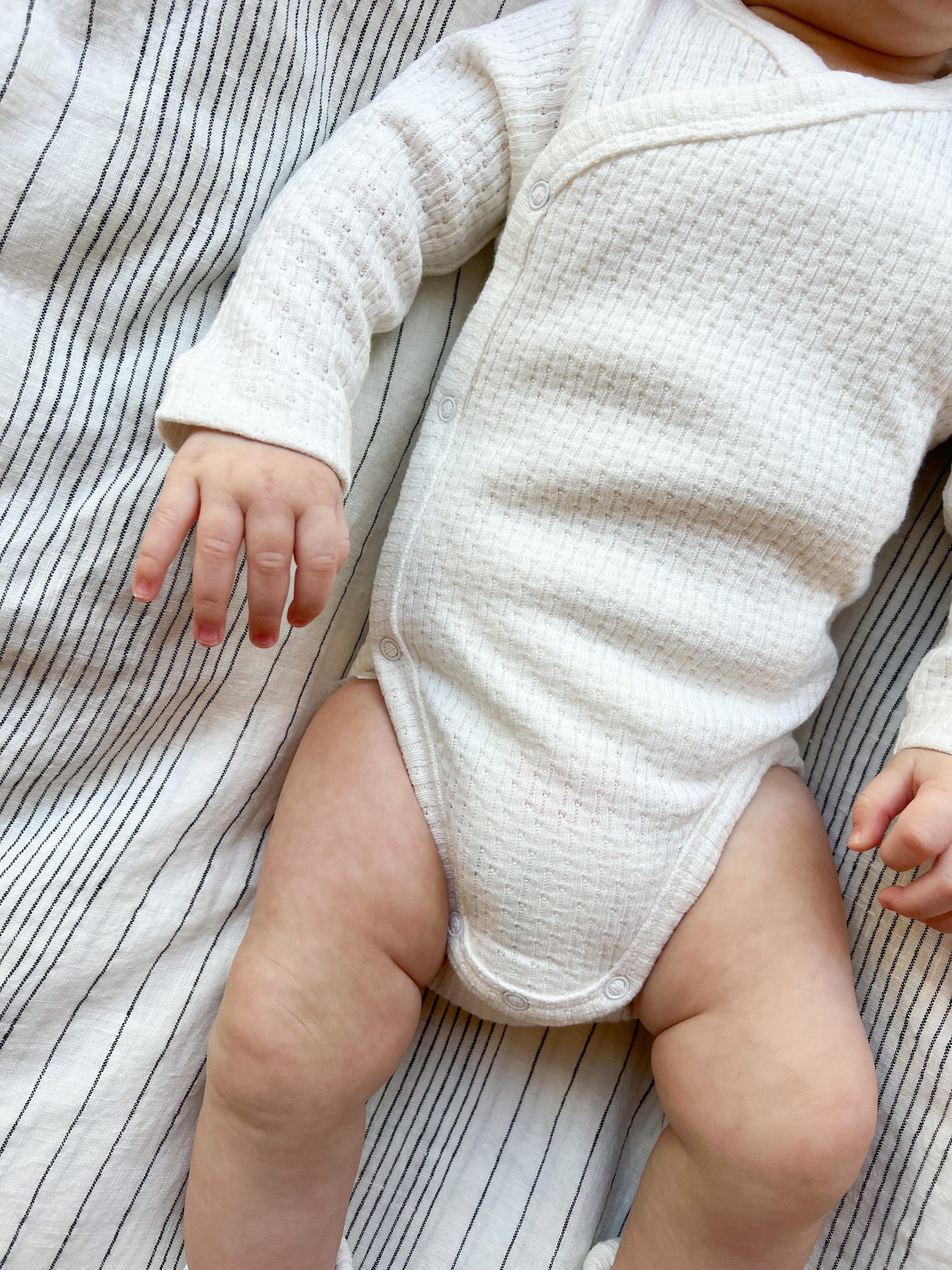 Baby wearing a Knitted Button Kimono in White