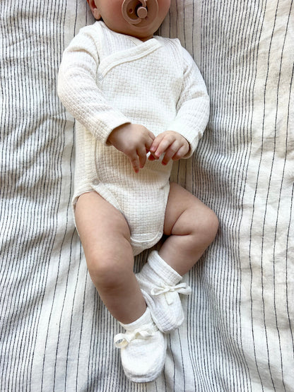 Baby wearing a Knitted Button Kimono in White 
