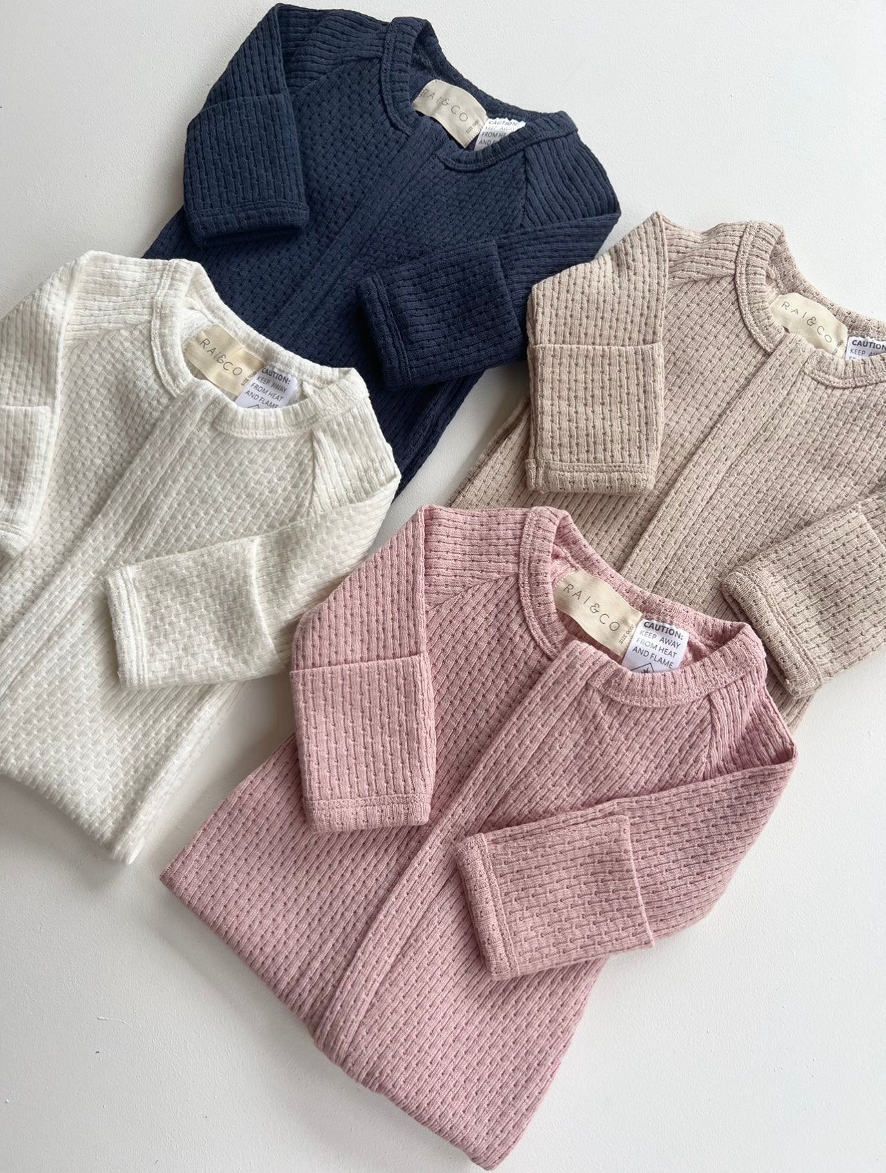four Knitted Onesie in Available Colours on a white background