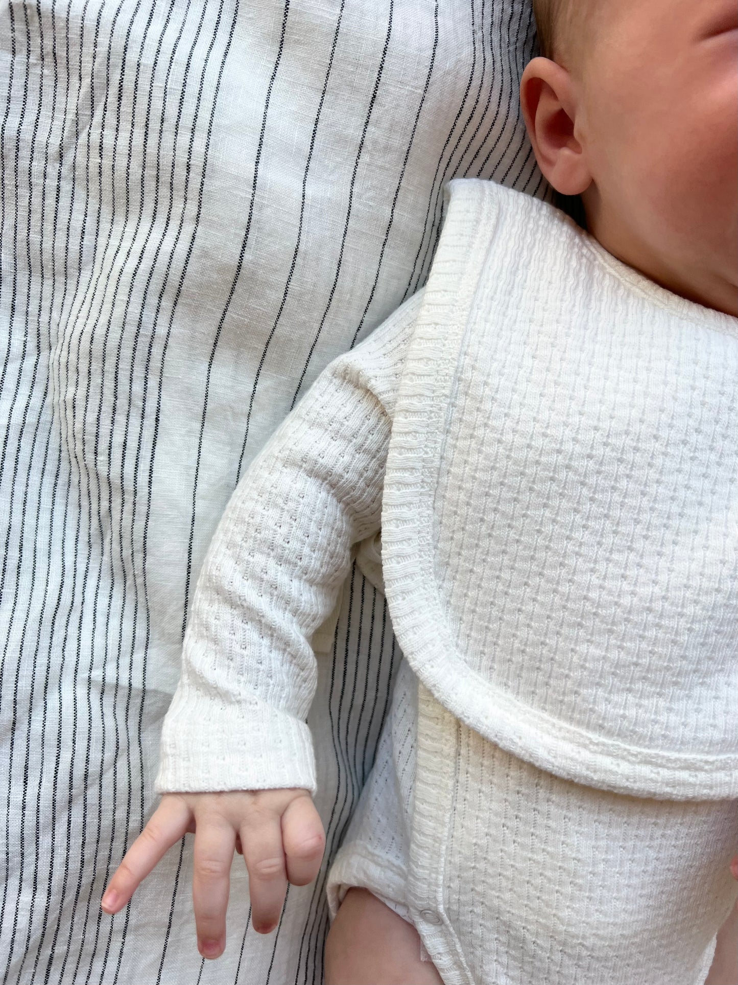 Baby wearing a Knitted Plain Bib in White
