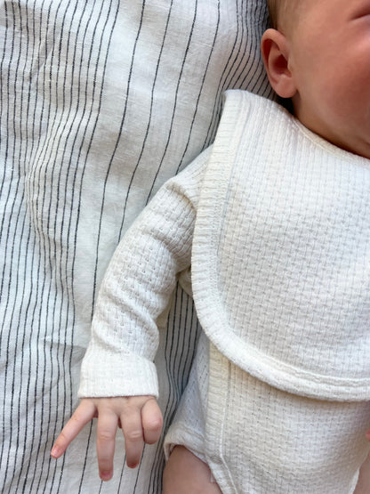 Baby wearing a Knitted Plain Bib in White