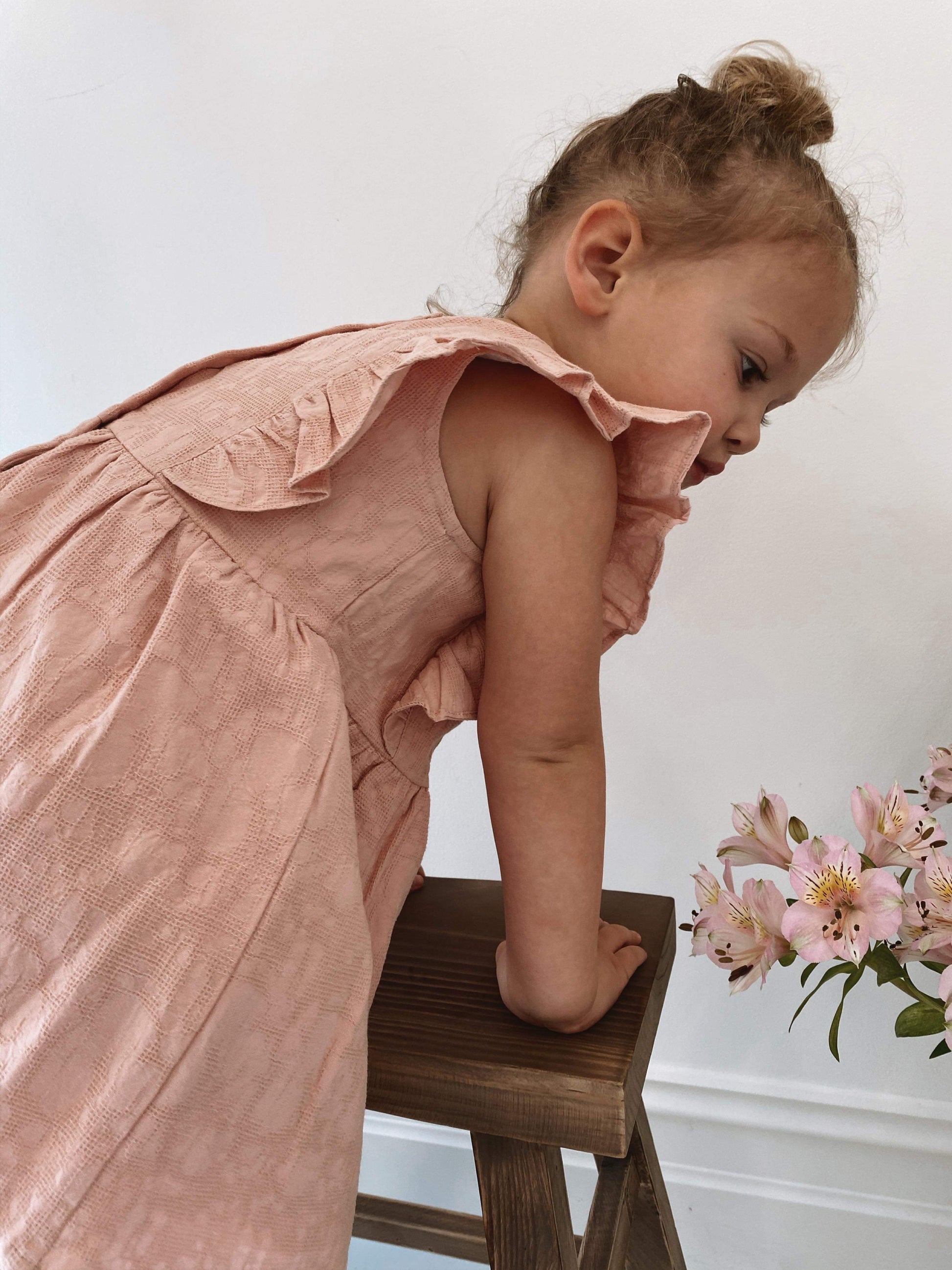 a young child wearing a Lou Lou Frilled Dress With Pilchers in Pink 